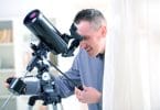 Man using reflector telescope