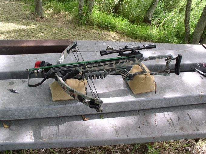 A crossbow with a scope ready for use on the table