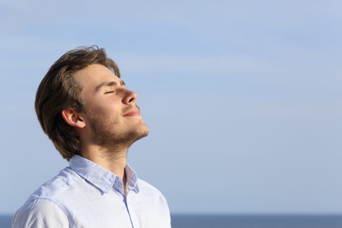 Happy young man breathing deep